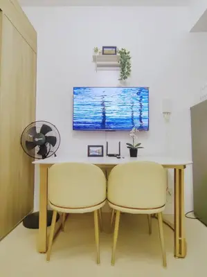 a dining room table with two chairs and a tv at 1BR Condotel with Balcony at FAME Residences #FM36 in Manila