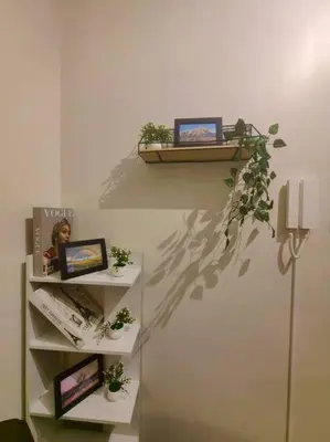 a shelf with plants and pictures on a wall at 1BR Condotel with Balcony at FAME Residences #FM37 in Manila
