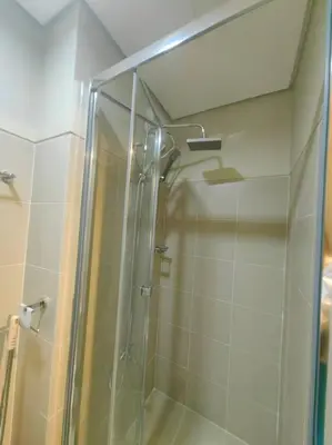a shower with a glass door in a bathroom at 1BR Condotel with Balcony at FAME Residences #FM37 in Manila