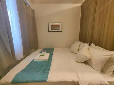 a white bed with a tray on top of it at 1BR Condotel with Balcony at FAME Residences #FM37 in Manila