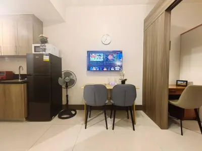 a kitchen with a table and two chairs and a refrigerator at 1BR Condotel with Balcony at FAME Residences #FM37 in Manila