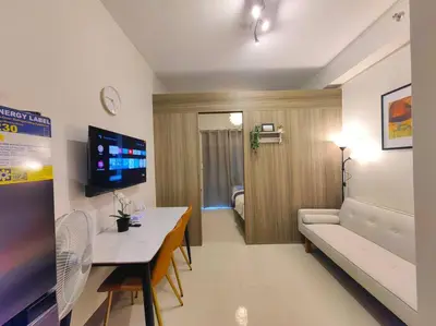a living room with a couch and a table in a room at 1BR Condotel with Balcony at FAME Residences #FM47 in Manila