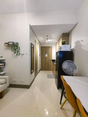 a kitchen with a dining table and a refrigerator at 1BR Condotel with Balcony at FAME Residences #FM47 in Manila