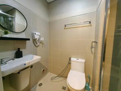 a bathroom with a toilet and a sink and a mirror at 1BR Condotel with Balcony at FAME Residences #FM47 in Manila