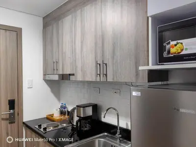 a kitchen with a sink and a microwave at Hotel style Unit 2924 Fame in Manila