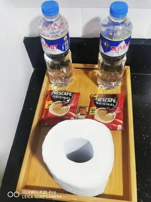 a wooden tray with two bottles of water and a toilet at Hotel style Unit 2924 Fame in Manila