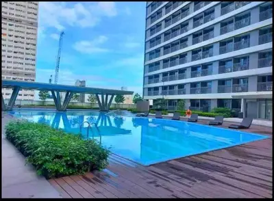 a large swimming pool with chairs and a building at Hotel style Unit 2924 Fame in Manila