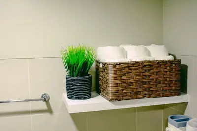 a bathroom with a basket of towels and a plant at Hotel style Unit 2924 Fame in Manila