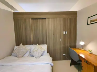 a bedroom with a bed with a desk and a computer at 1BR Condotel with Balcony at FAME Residences #FM51 in Manila