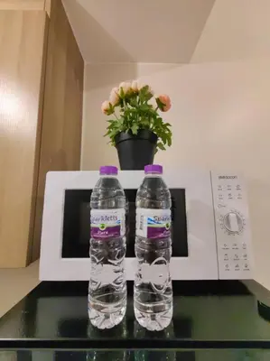 two bottles of water sitting on top of a microwave at 1BR Condotel with Balcony at FAME Residences #FM51 in Manila