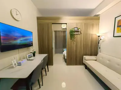 a living room with a couch and a table and a room with a couch at 1BR Condotel with Balcony at FAME Residences #FM51 in Manila