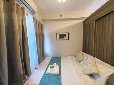 a bedroom with a bed with a tray on it at 1BR Condotel with Balcony at FAME Residences #FM51 in Manila