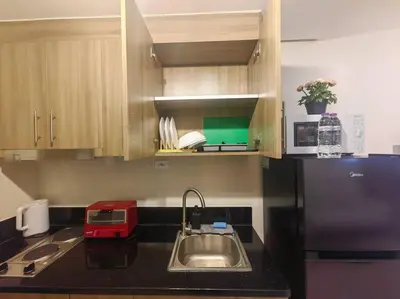 a kitchen with a sink and a refrigerator at 1BR Condotel with Balcony at FAME Residences #FM52 in Manila