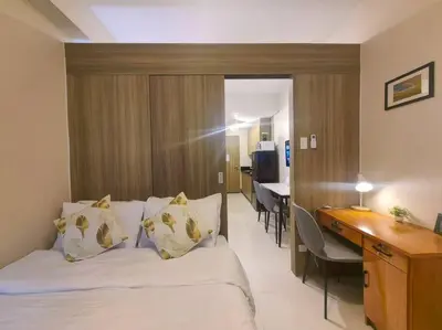 a hotel room with a bed and a desk and a kitchen at 1BR Condotel with Balcony at FAME Residences #FM52 in Manila