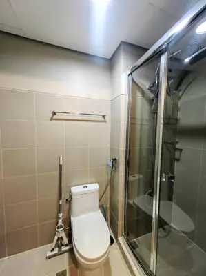 a bathroom with a toilet and a glass shower at 1BR Condotel with Balcony at FAME Residences #FM52 in Manila