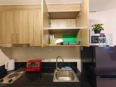 a kitchen with a sink and a black refrigerator at 1BR Condotel with Balcony at FAME Residences #FM52 in Manila