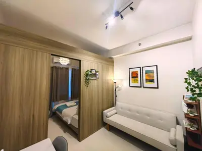 a bedroom with a bed and a couch in a room at 1BR Condotel with Balcony at FAME Residences #FM52 in Manila