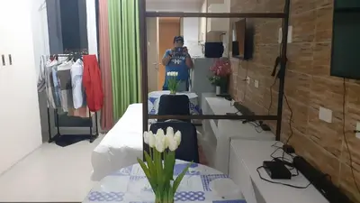 a woman standing in front of a mirror in a dressing room at Jinh's place to STAYCATION in Manila
