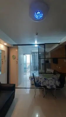 a living room with a table and a bed at Jinh's place to STAYCATION in Manila