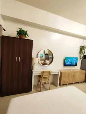 a bedroom with a mirror and a desk with a chair at Jinh's place to STAYCATION in Manila
