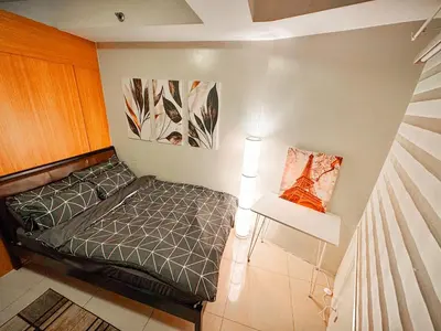a small bedroom with a bed and a table at 823 Air Condo Shell Staycation Mall of Asia Walkable in Manila