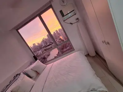 a bedroom with a bed and a large window at Mi Casa - Cozy Studio with FREE access to Fitness Centre, swimming pool and stunning City View located near the CBD of Ortigas, Makati, BGC in Manila