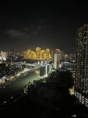 a city skyline at night with a river and buildings at Mi Casa - Cozy Studio with FREE access to Fitness Centre, swimming pool and stunning City View located near the CBD of Ortigas, Makati, BGC in Manila
