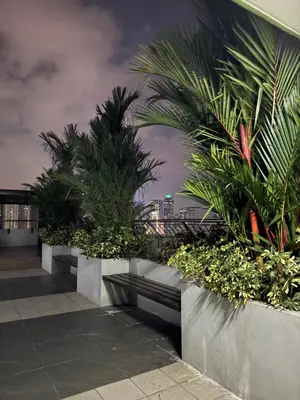 a building with palm trees on the side of it at Mi Casa - Cozy Studio with FREE access to Fitness Centre, swimming pool and stunning City View located near the CBD of Ortigas, Makati, BGC in Manila