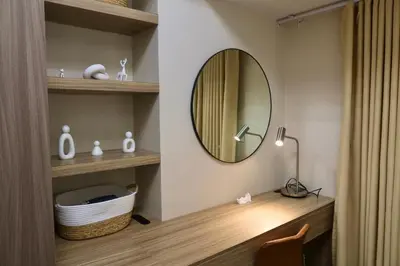 a bathroom with a vanity with a mirror and a lamp at Park Mckinley West 1BR in Manila