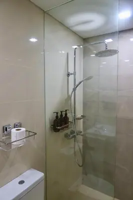 a shower with a glass door in a bathroom at Park Mckinley West 1BR in Manila