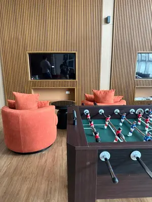 a living room with a table with a gamecussioncussioncussioncussioncussioncussioncussion at Park Mckinley West 1BR in Manila
