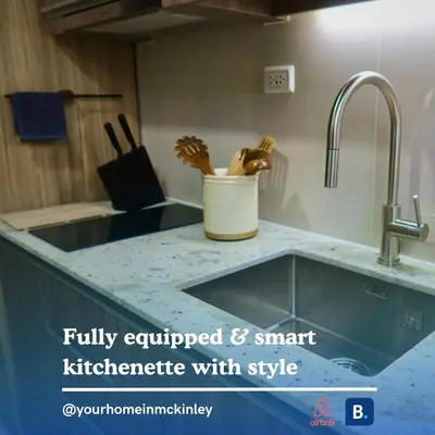 a kitchen counter top with a sink and a kitchen utensils at Park Mckinley West 1BR in Manila