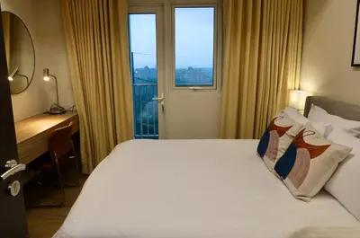 a bedroom with a bed with a desk and a window at Park Mckinley West 1BR in Manila