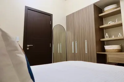 a bedroom with a bed and a black door and shelves at Park Mckinley West 1BR in Manila