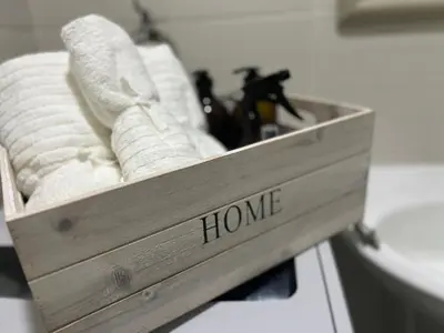 a wooden box of towels with the word home on it at Cozy 1 Bedroom Makati Condo with Balcony Wifi in Manila