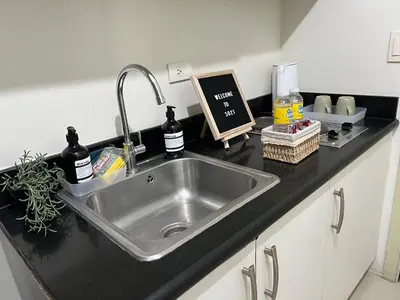 a kitchen counter with a stainless steel sink at Cozy 1 Bedroom Makati Condo with Balcony Wifi in Manila