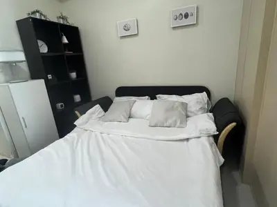 a bedroom with a bed with white sheets and pillows at Cozy 1 Bedroom Makati Condo with Balcony Wifi in Manila