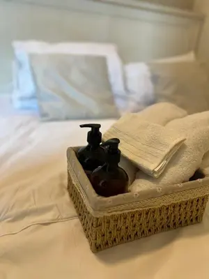 a basket with two bottles on a bed at Cozy 1 Bedroom Makati Condo with Balcony Wifi in Manila