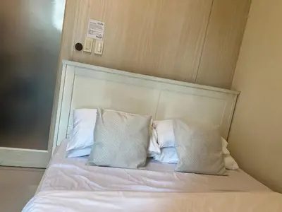 a bed with two pillows on top of it at Cozy 1 Bedroom Makati Condo with Balcony Wifi in Manila