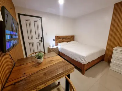 a bedroom with a bed and a wooden table at Flat 35, Unit 1B in Manila