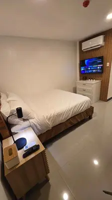 a bedroom with a bed and a tv on a wall at Flat 35, Unit 1B in Manila