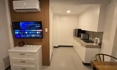 a small kitchen with a tv on a wall at Flat 35, Unit 1B in Manila