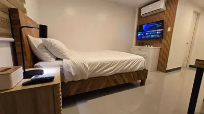 a bedroom with a bed with a television in it at Flat 35, Unit 1B in Manila