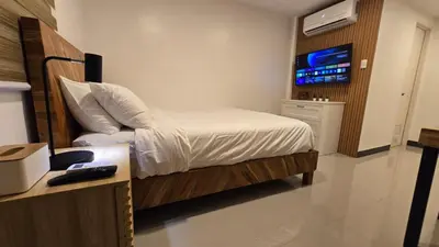 a bedroom with a bed and a desk and a television at Flat 35, Unit 1B in Manila