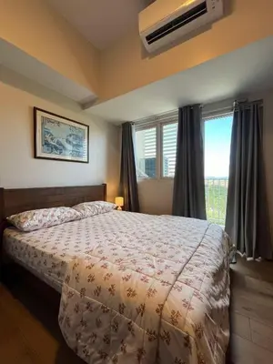 a bedroom with a bed and a large window at Park McKinley West unit 9Y Tower B in Manila