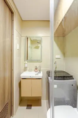 a bathroom with a sink and a toilet and a mirror at The Manor at S Residences in Manila
