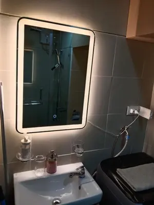 a bathroom with a sink and a mirror and a toilet at The Manor at S Residences in Manila