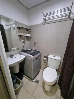 a small bathroom with a toilet and a sink at Industrial Design Bachelor's Pad with Pool View in Shore Residences in Manila
