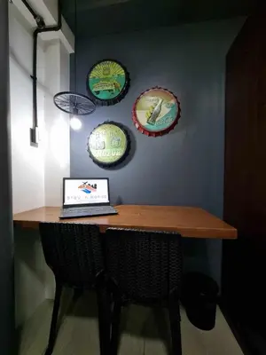 a table with a laptop on it with plates on the wall at Industrial Design Bachelor's Pad with Pool View in Shore Residences in Manila