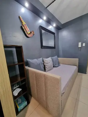 a room with a bed with a baseball bat on the wall at Industrial Design Bachelor's Pad with Pool View in Shore Residences in Manila